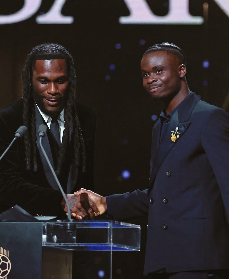 Burna Boy and Bukayo Saka shaking hands on stage at the Ballon d&rsquo;Or, beside the podium